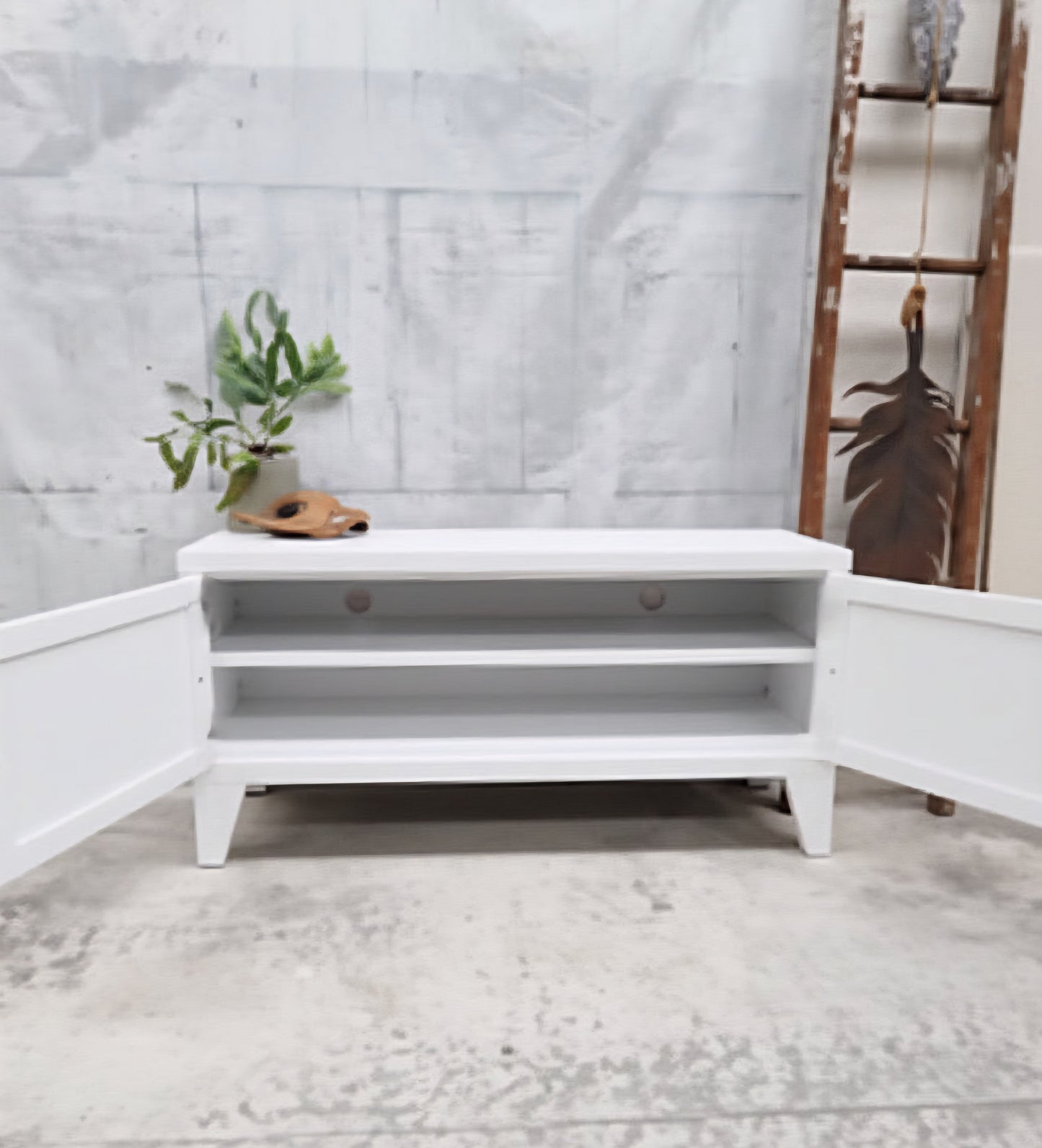 White metal TV cabinet with door open showing cable holes and shelf