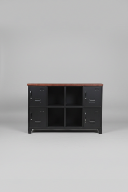 Black industrial locker-style cabinet with display middle with wooden top in a room with plants and white wall.