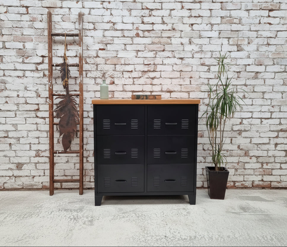 Black metal dresser with recycled Rimu wooden top against a light gray wall.