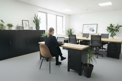 Black metal industrial locker desk with oak top, person sitting in chair in office
