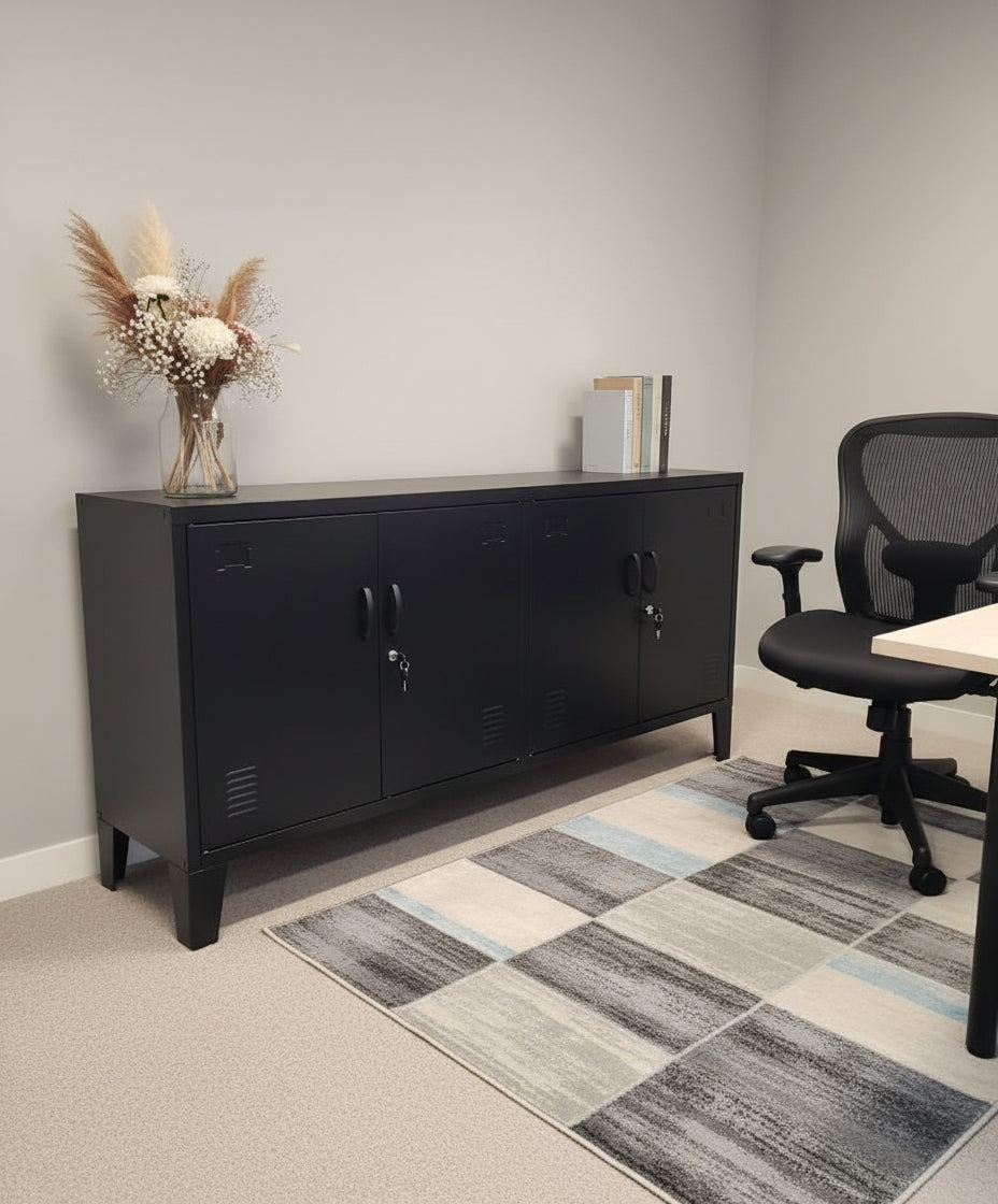 Black metal lockable office cabinet with a vase of flowers, black office chair, and a checkered rug on a light gray floor.