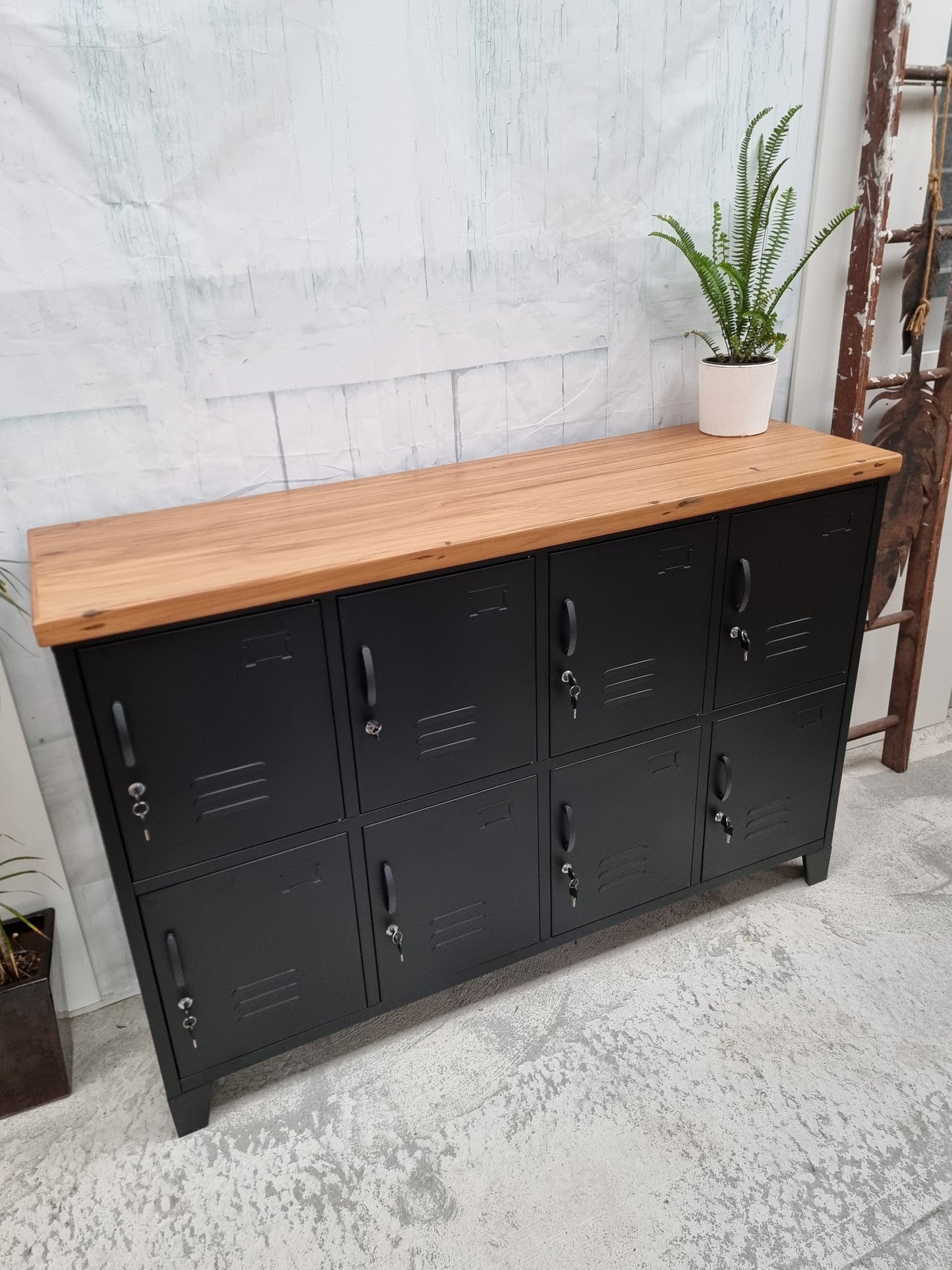 Black metal locker-style sideboard cabinet with recycled Rimu top against a light gray wall.