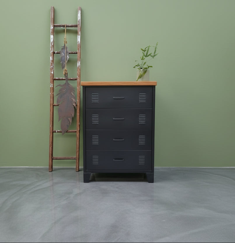 Black metal tallboy cabinet with 4 drawers and a RImu top on a green wall