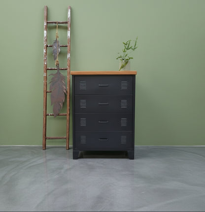 Black metal tallboy cabinet with 4 drawers and a RImu top on a green wall