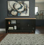 Black metal versatile cabinet with Rimu top in a room with plants and decor.