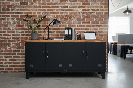 Black versatile metal cabinet with Rimu top against a brick wall in an office setting