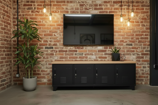 Large Black industrial metal cabinet with Oak top with a TV mounted on a brick wall, featuring a plant and decorative items