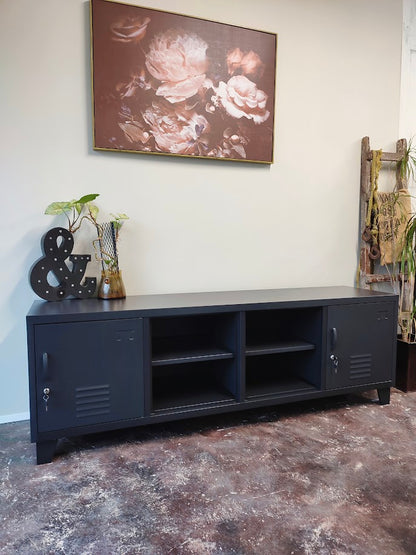 Large Black metal cabinet with open display shelves for decorative items on a textured floor, floral painting on the wall.
