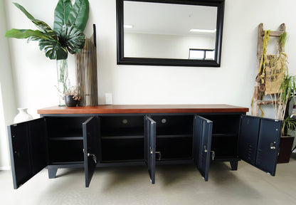Large black Industrial metal entertainment cabinet with dark oak top with the doors open to show cable holes and shelves inside.