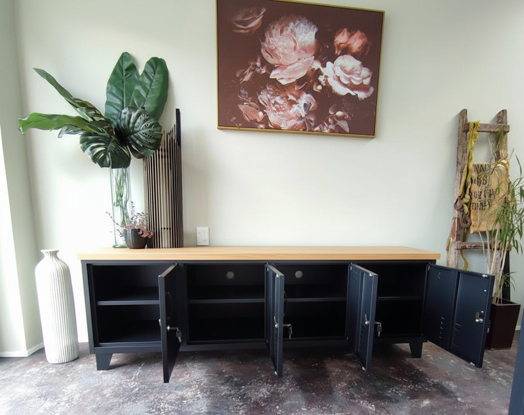 Large black industrial TV cabinet with Oak top open doors in a room with a floral painting on the wall.