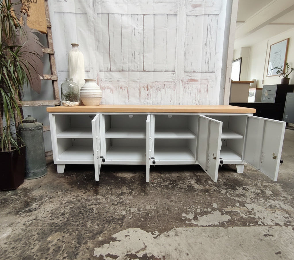 Large white industrial entertainment console with oak top with open doors to show cable holes and shelves inside 