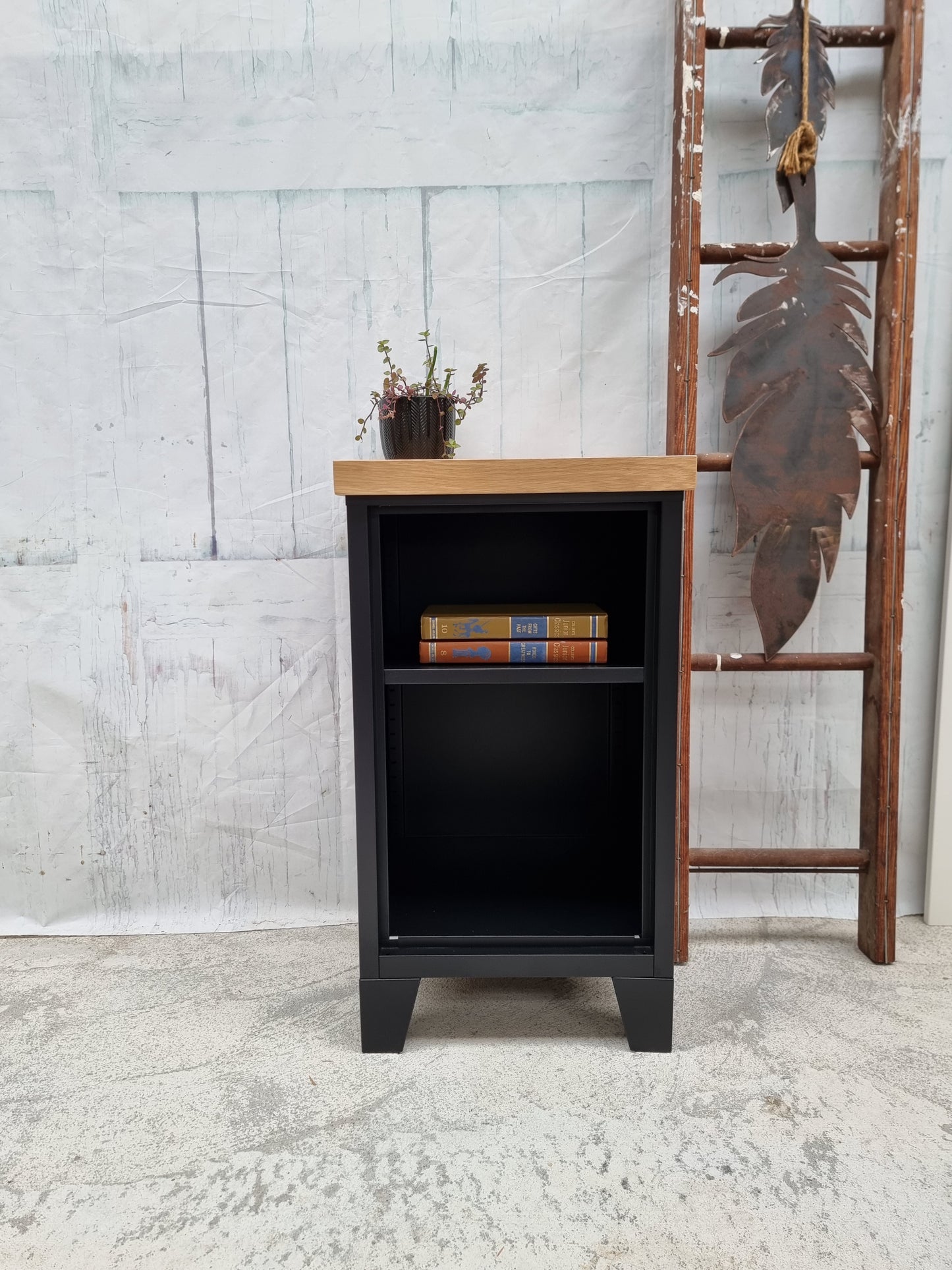 Small black metal industrial bookshelf with a Oak top