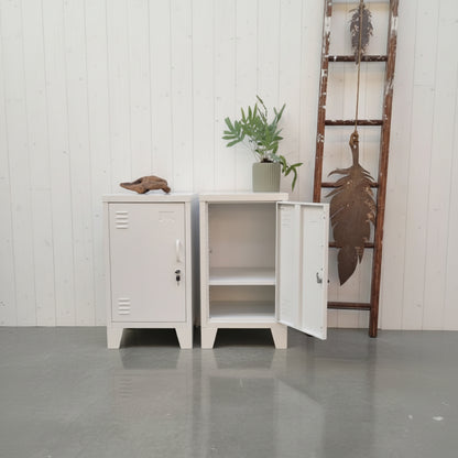Two small vintage-style metal  lockers against a concrete wall with decorative elements.