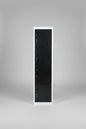 Tall black locker with white frame in a warehouse setting