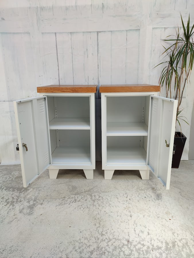 A Pair White metal beside cabinet with Rimu tops open doors. featuring a wooden top against a light gray wall.