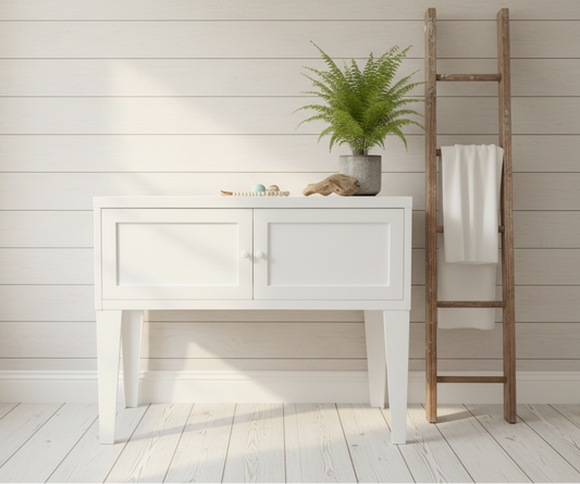 White metal console table against a  wall with decorative elements.
