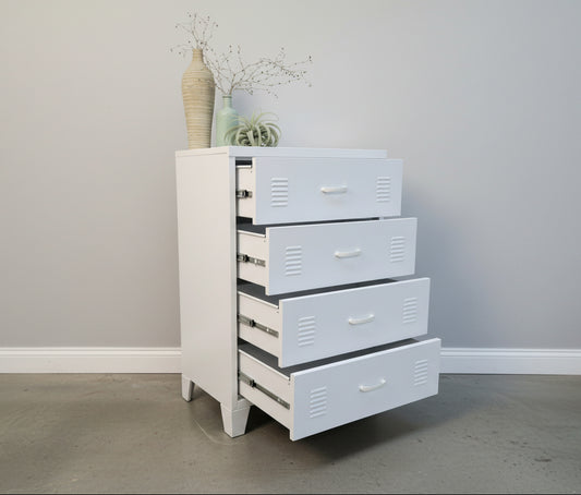 White metal dresser with 4 drawers open against a light-colored wall.
