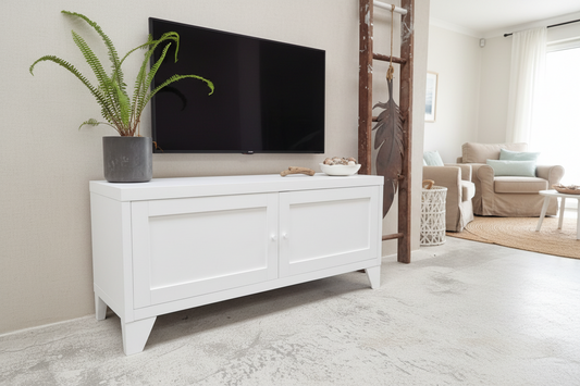 White metal entertainment console with a TV and plant in a living room setting