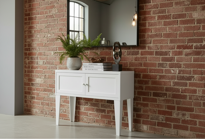 White metal console table against a brick wall