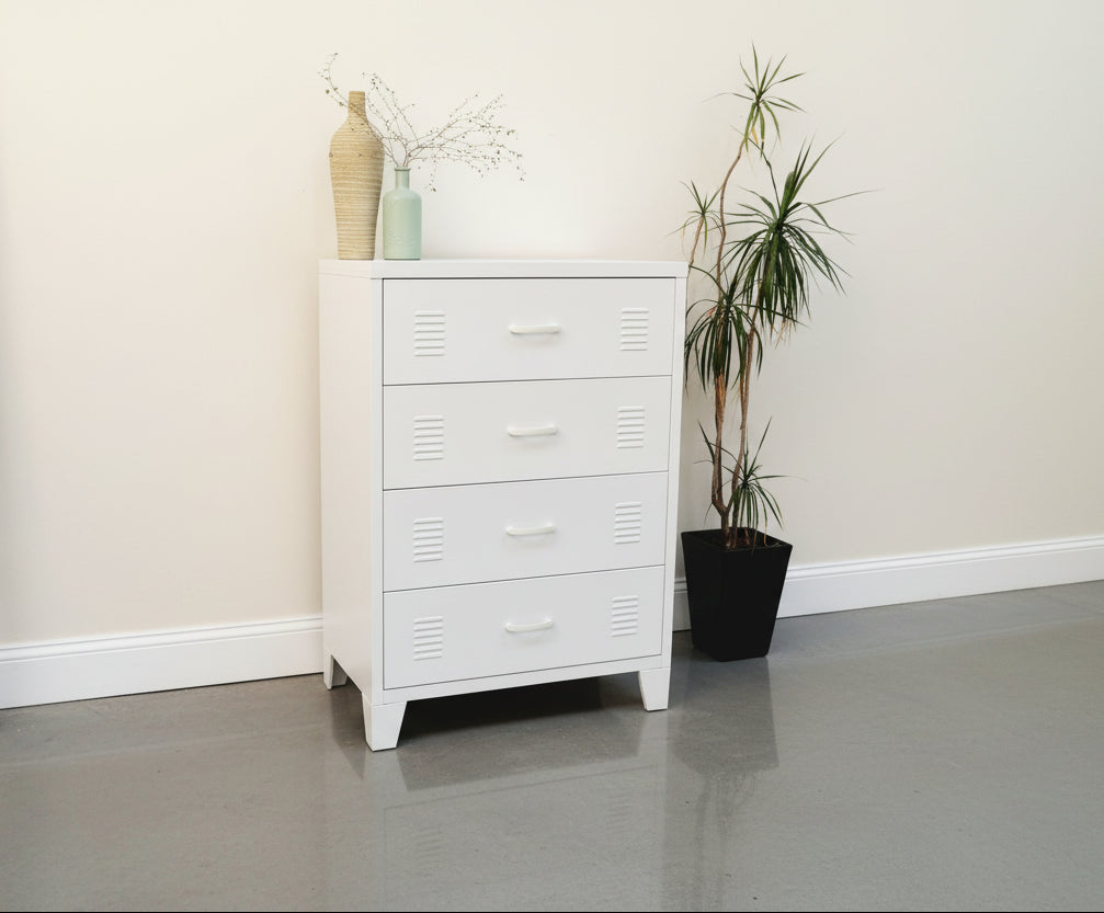 White metal locker-style dresser with decorative vases and plants in a room setting.