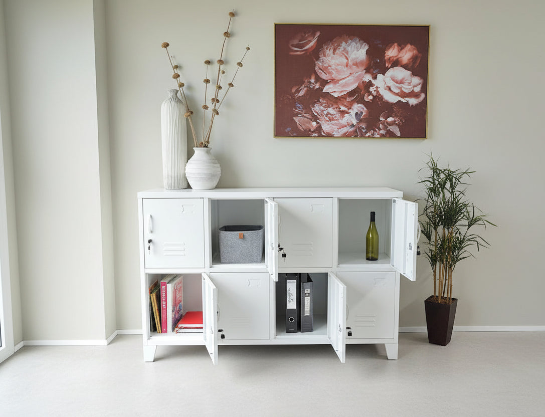 White metal storage cabinet locker with open doors displaying books and a bottle, with a floral painting on the wall.