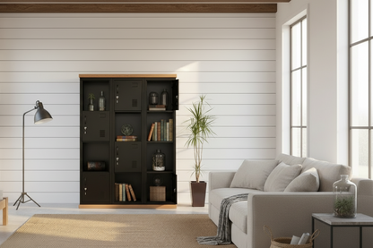 A black metal checkerboard display locker cabinet with a Rimu wood top and plinth, containing various items and placed next to a potted plant.