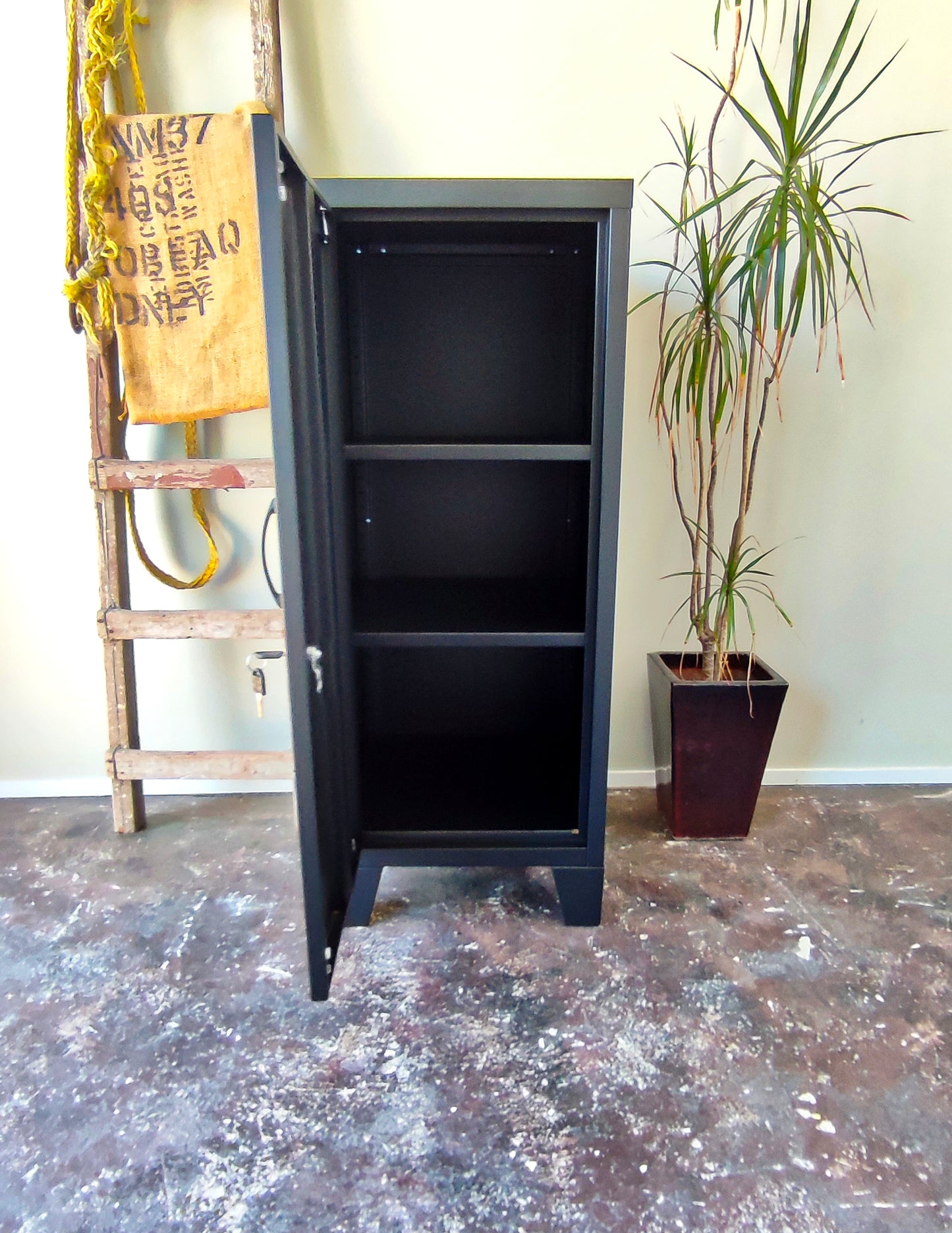 black metal side cabinet with left opening door, door open showing adjustable shelves