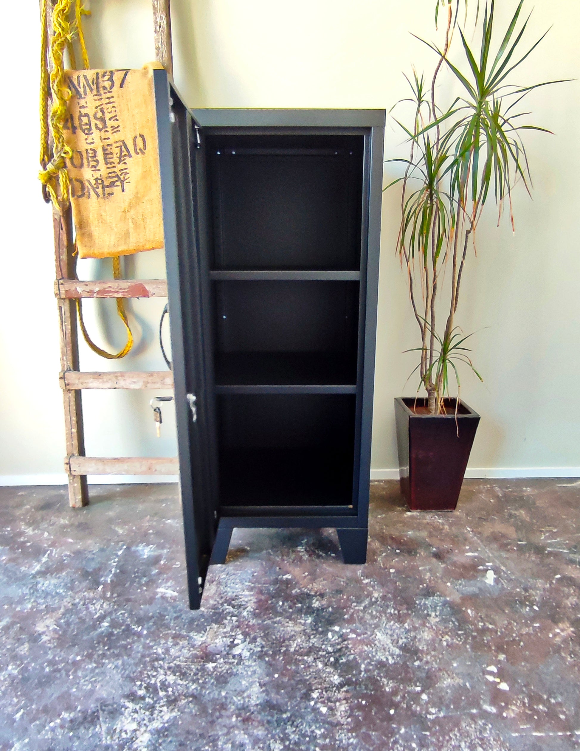 black metal side cabinet with left opening door, door open showing adjustable shelves