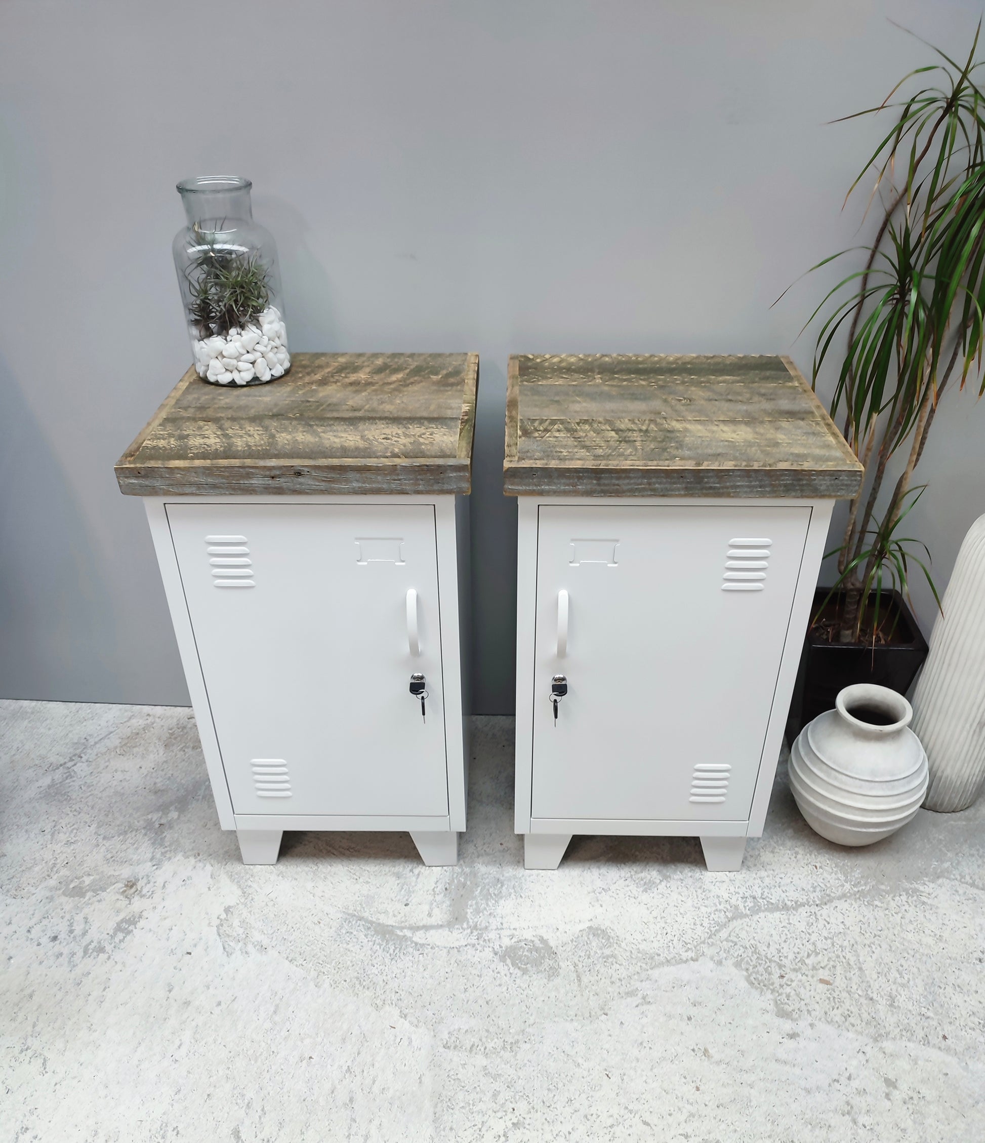 A pair of white metal mini locker cabinets with pallet tops