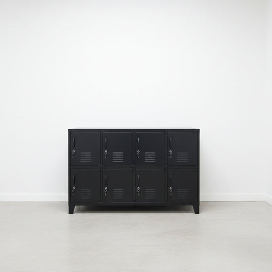 A large black metal locker cabinet with 8 lockable doors stands in a high-ceilinged industrial room.