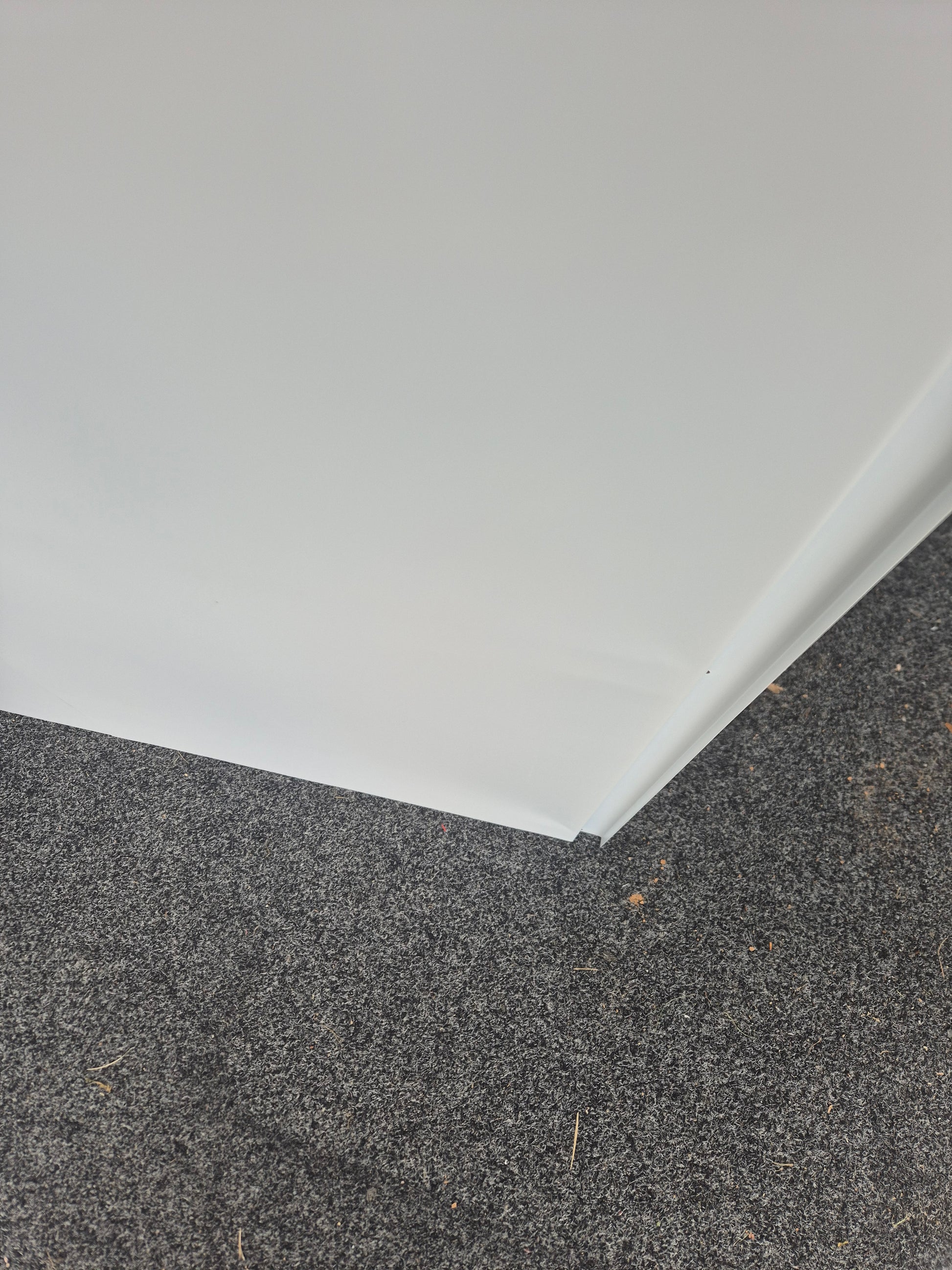 Close-up of a corner where a white wall meets a gray concrete floor.