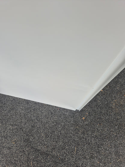 Close-up of a corner where a white wall meets a gray concrete floor.