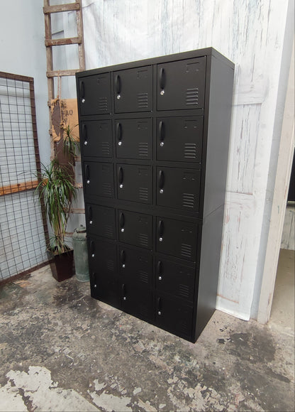 Black metal locker with multiple compartments in an industrial setting.