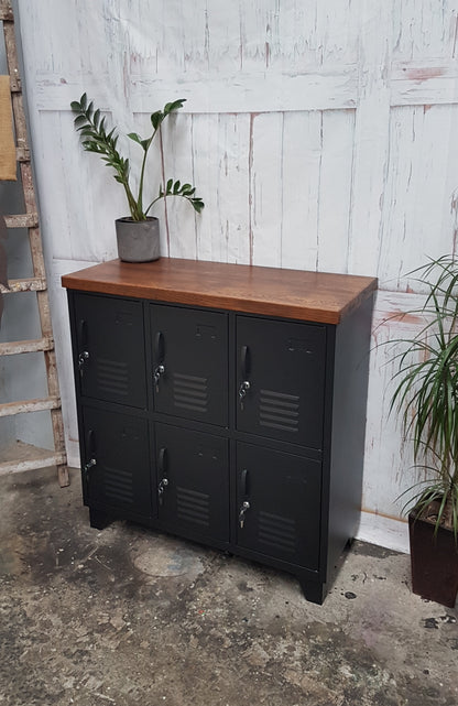 A Black Metal 6-door locker with dark oak top, with a ZZ plant on top in industrial setting