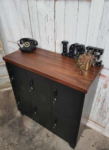 Black metal locker-style cabinet with Dark stained Rimu top against a rustic wall. Industrial style