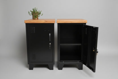 Two black mini lockers with recycled Rimu tops, one with the door open showing the interior shelf, the other with the door closed. Set against a weathered wooden backdrop.