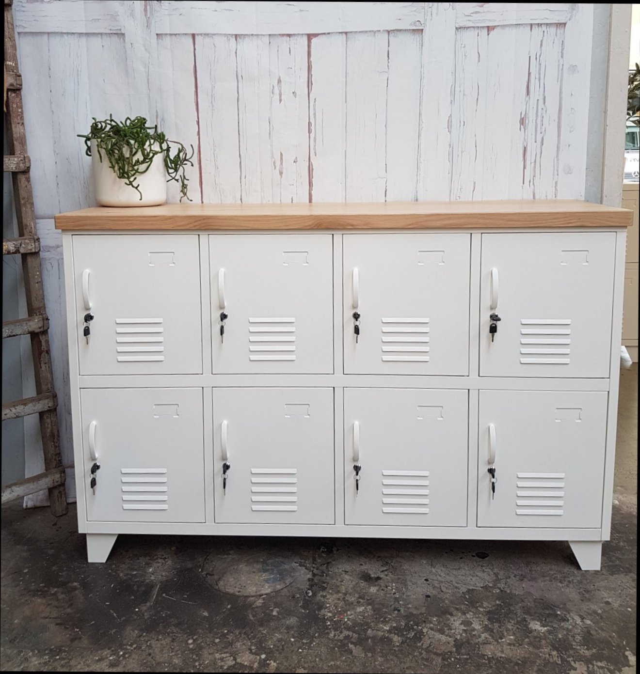A white 8-door sideboard locker with an oak top, featuring multiple small lockers beneath the oak surface.