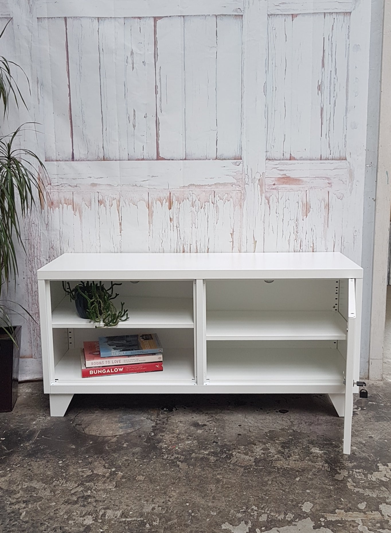 White metal TV cabinet with open display, showing the door open with adjustable shelf and cable hole