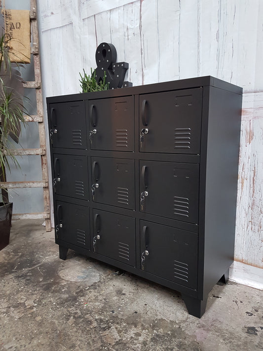 A matte/satin black 9-door locker with a industrial style design, featuring individual compartments with handles.