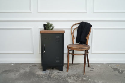 black right opening metal locker next to rustic chair 