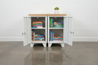 two white mini lockers with beautiful oak top shown with books inside 